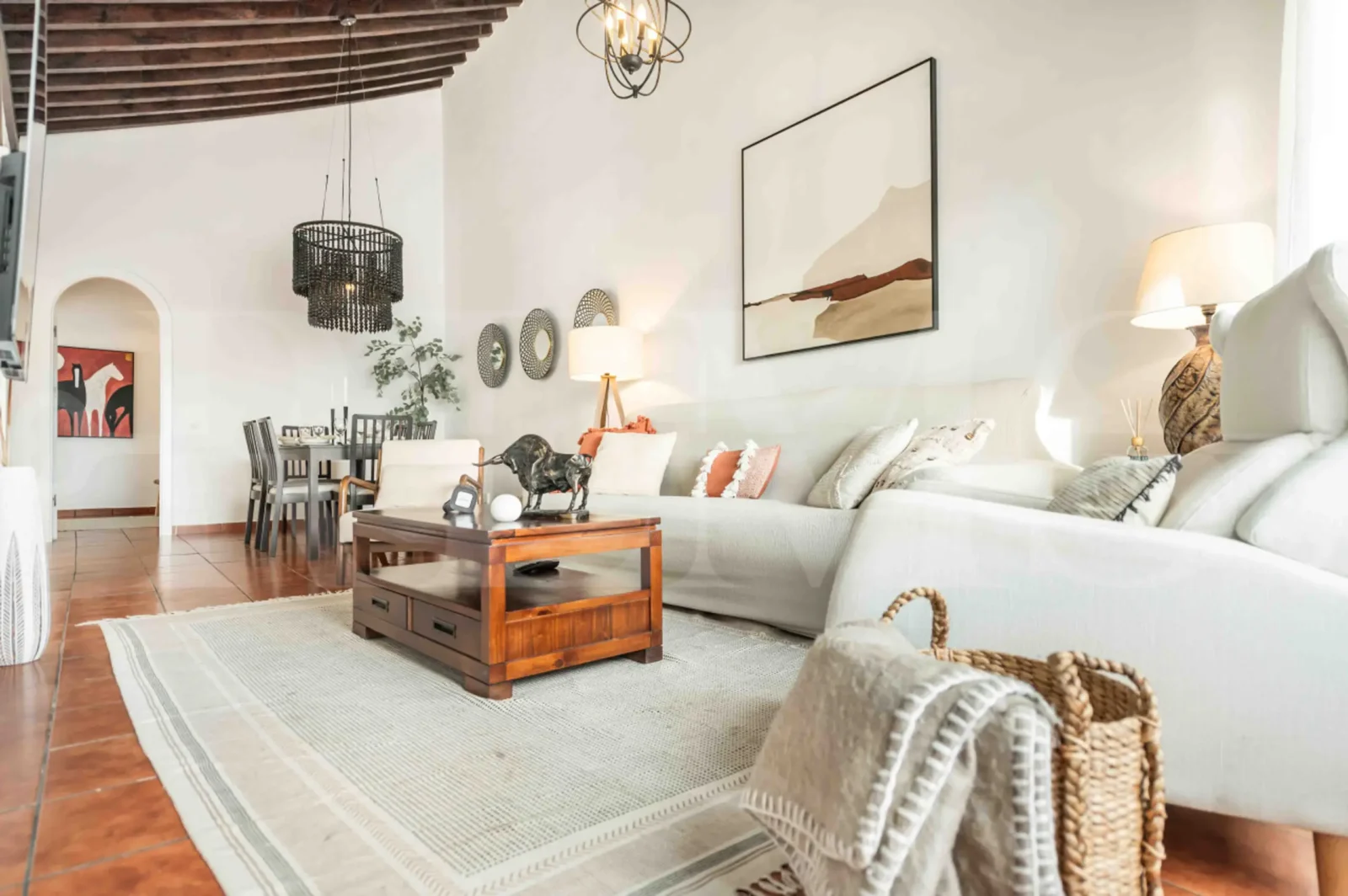 Stylish Andalusian-inspired living room with natural light, terracotta floors, and cozy neutral-toned furnishings in a luxury apartment for 4 guests in Malaga, Spain.