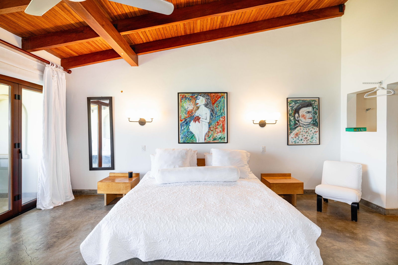 Stylish bedroom with vaulted ceiling, original artwork, and modern rustic design – Charity Ace Costa Rica vacation stay