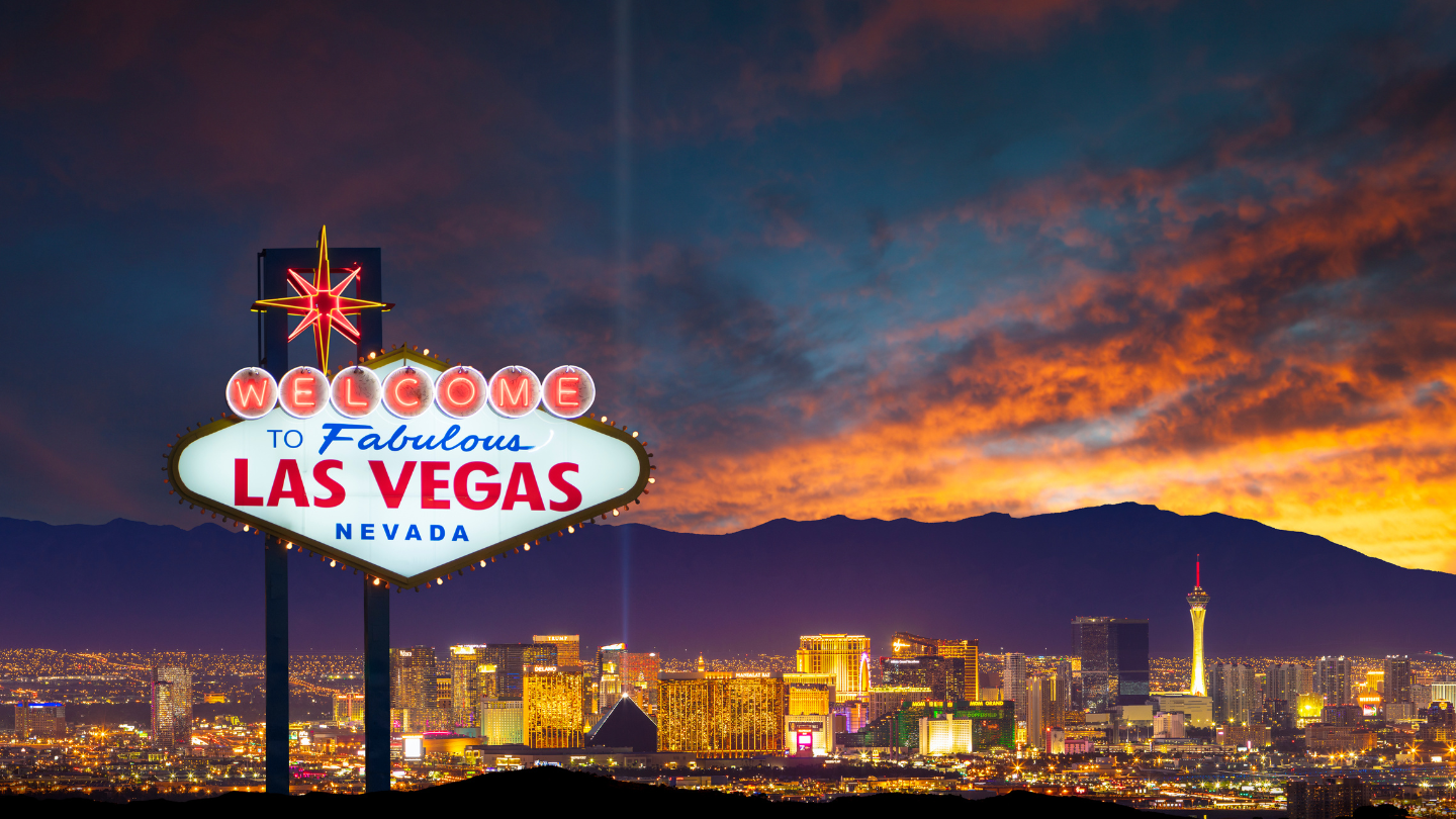 Las Vegas Strip at Dusk – The famous "Welcome to Fabulous Las Vegas" sign glows as the city skyline lights up against a stunning desert sunset. A thrilling CharityACE travel package for an electrifying Las Vegas getaway.
