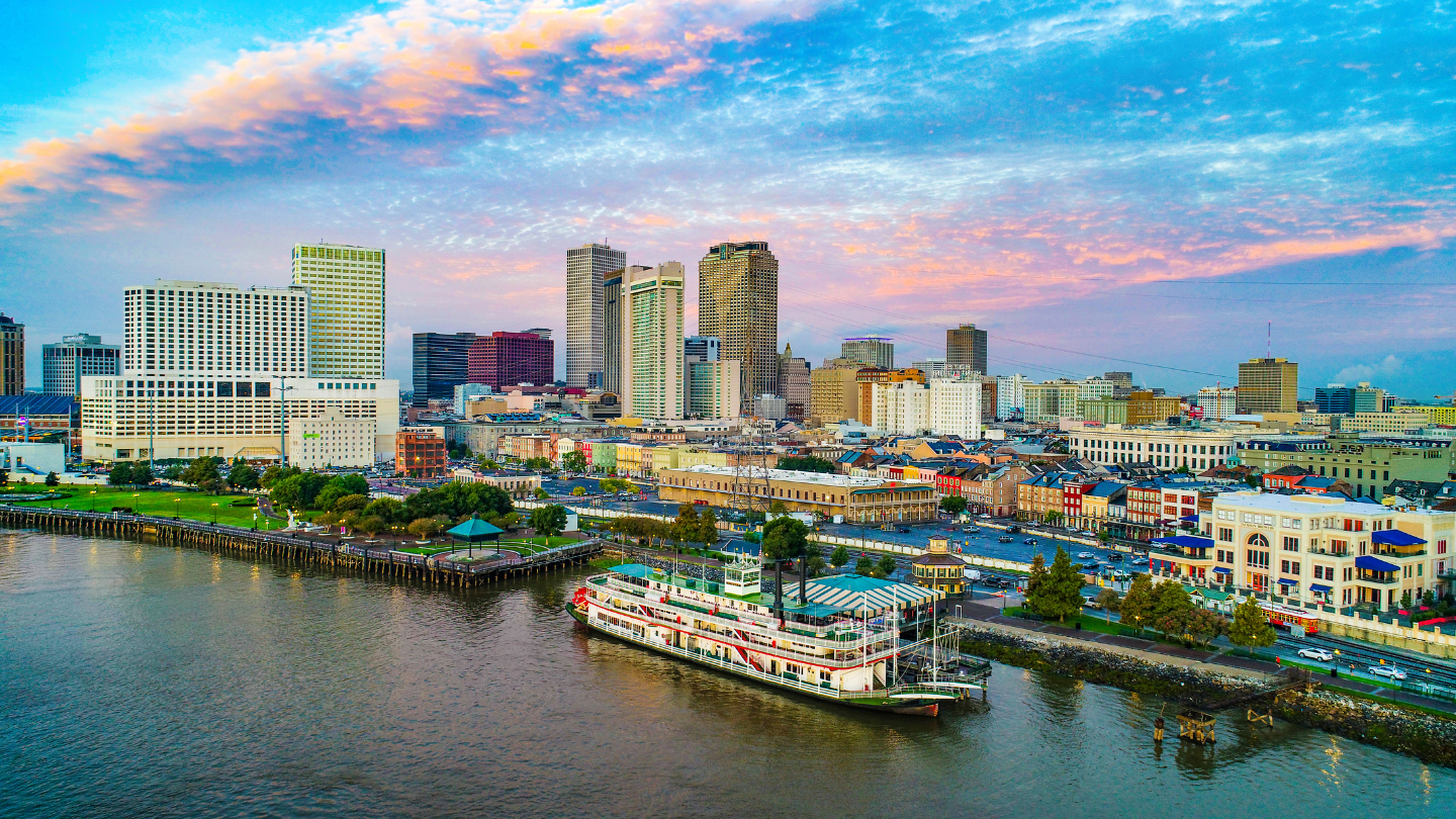 New Orleans Riverfront and Skyline – A classic New Orleans steamboat floats on the Mississippi River, with the city's vibrant skyline in the background, capturing the spirit of jazz, Creole cuisine, and rich history. A perfect CharityACE package for an unforgettable cultural escape.