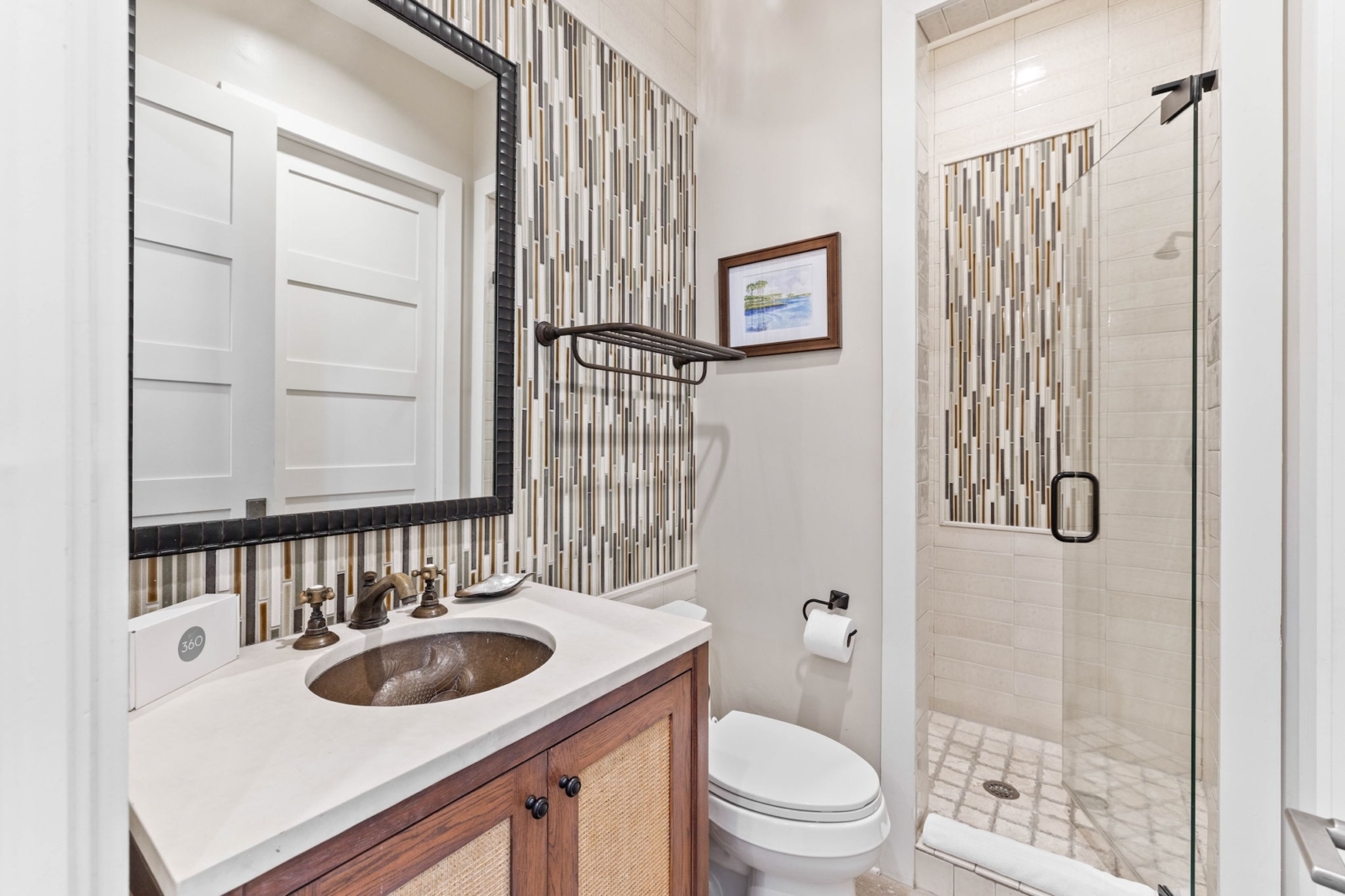 Modern bathroom with walk-in shower, mosaic tile accents, and rustic vanity in Watercolor, Florida rental home