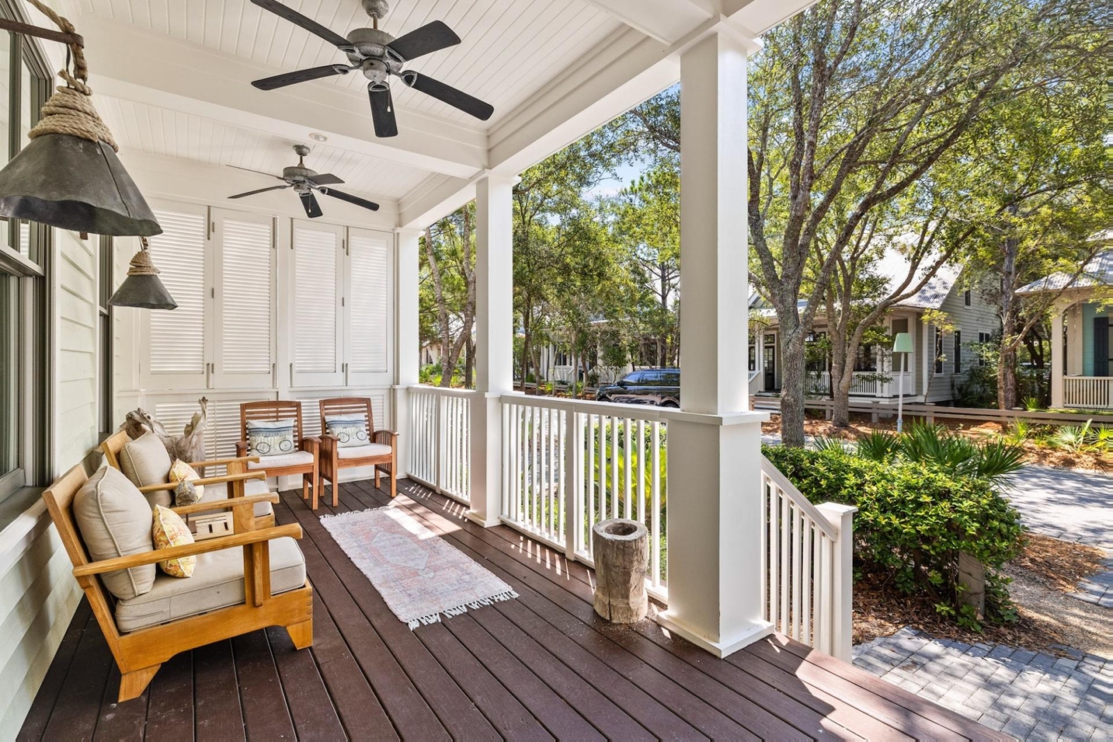 Inviting front porch with cushioned seating and ceiling fans in a charming Watercolor, Florida beach house