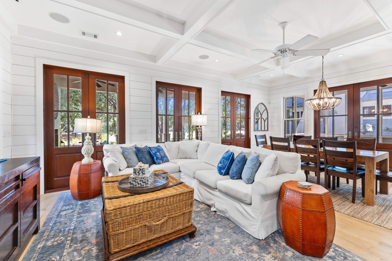 Bright and airy living room with white sectional sofa, coastal decor, and open dining space in luxury Watercolor, Florida vacation rental