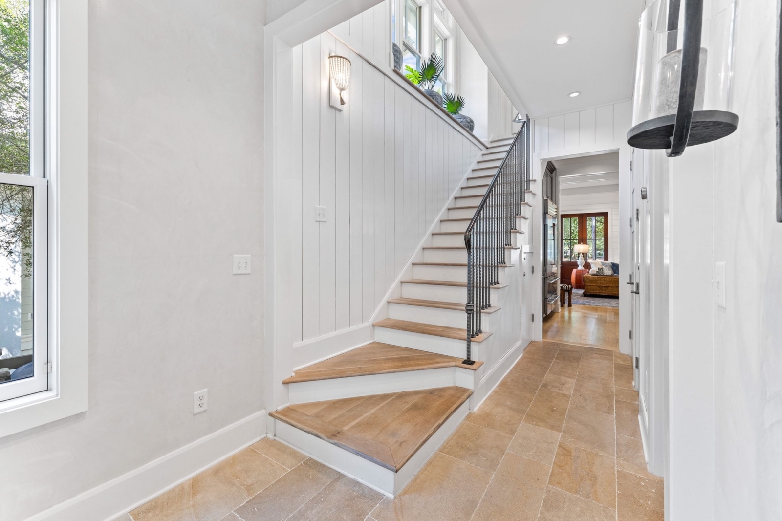 Elegant entryway with natural light, wood staircase, and modern coastal design in Watercolor, Florida luxury home