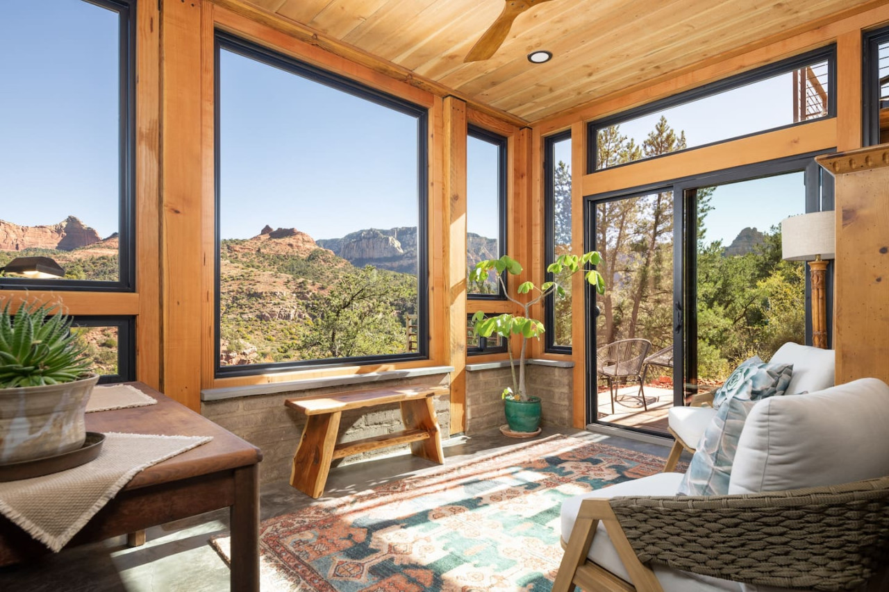 Bright sunroom with mountain views and access to outdoor patio in Sedona retreat.