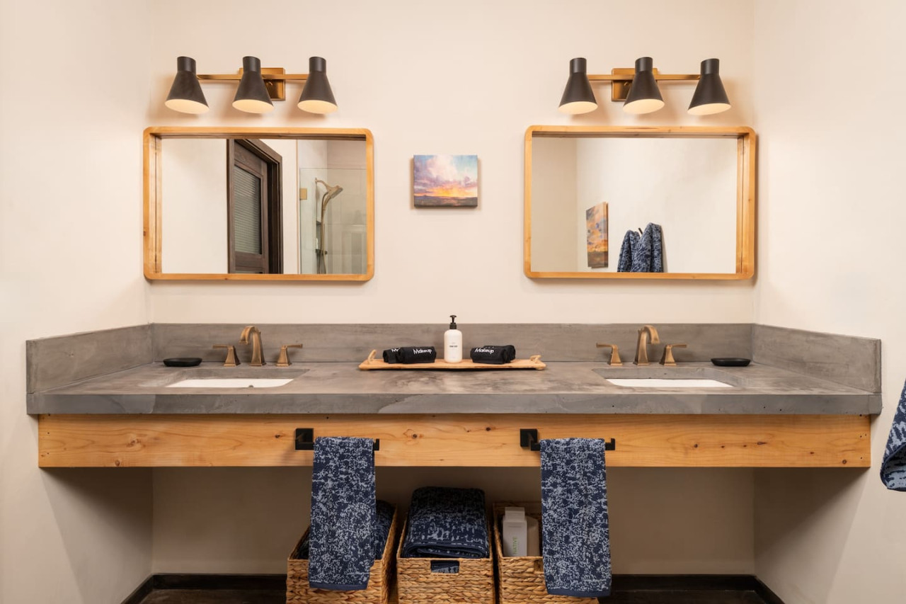 Dual-sink bathroom with concrete countertops and warm lighting in Sedona luxury rental.